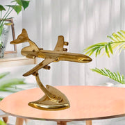 A handcrafted brass aeroplane model with gold finishing, displayed on a table.