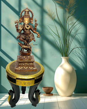 Decorative statue on a pedestal with a vase and plant against a teal wall.