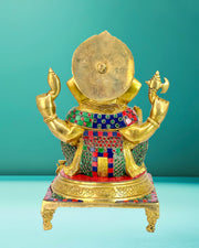 Decorative statue with gold and multicolored elements on a teal background,