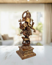 Bronze statue of a deity on a white surface with a blurred indoor background
